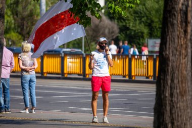 Minsk, Belarus, 30 Ağustos 2020. Başkanlık seçimlerinden sonra barışçıl protestolar. Adam bayrağı elinde tutuyor.. 