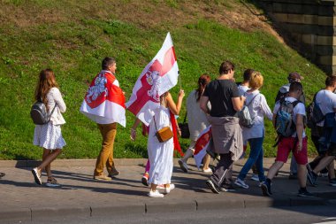Minsk, Belarus, 30 Ağustos 2020. Başkanlık seçimlerinden sonra barışçıl protestolar. Bayrakları ellerimde, omuzlarımda taşıyorum.