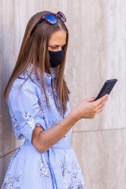 Yüz maskesi ile korunan beyaz ergen, çovid 'de 19 kez akıllı telefon kullanıyor.. 