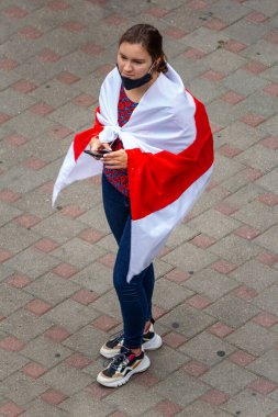 Minsk, Belarus - Eylül 06, 2020. Beyaz Rusya 'da yapılan cumhurbaşkanlığı seçimlerinden sonra görevdeki hükümete karşı barışçıl protesto eylemleri. Omuzlarında bayrak taşıyan bir kız.