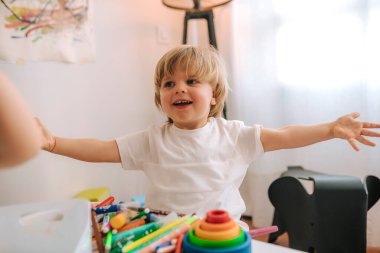 Sarışın çocuk evde resim yapıyor. Karantina sırasında eğlence. Koronavirüsteki aile.