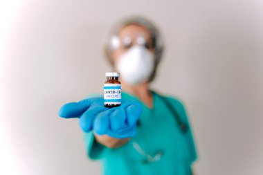 COVID-19 Coronavirus aşısı. Doktor bilim adamı Sars-CoV-2 virüsünü analiz ediyor. Klinik deney için aşı araştırması yapıyor. Kadın araştırmacı, potansiyel aşıyı laboratuvarda test ediyor. Savaşan Covid-19