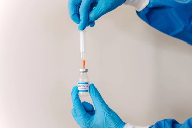 COVID-19 Coronavirus aşısı. Doktor bilim adamı Sars-CoV-2 virüsünü analiz ediyor. Klinik deney için aşı araştırması yapıyor. Kadın araştırmacı, potansiyel aşıyı laboratuvarda test ediyor. Savaşan Covid-19