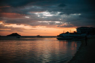 Filipinler 'de bir kumsalda gün batımı ardında güzel renkler bırakan bir fırtınadan sonra