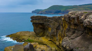 Kenarında bir kişinin belirdiği bir Cantabrian uçurumu manzarası.