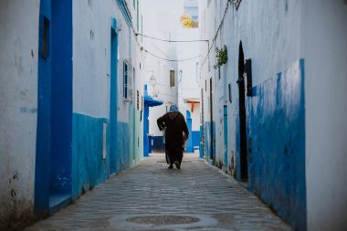 Asilah, Fas - 19 Eylül 2019: Mavi & beyaz & kırmızı tarzlı dar bir sokak.