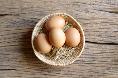 ahşap arka plan üzerinde hasır sepet yumurta