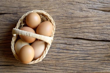 ahşap arka plan üzerinde hasır sepet yumurta