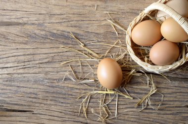 ahşap arka plan üzerinde hasır sepet yumurta
