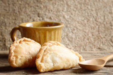 Puff ahşap masa üzerinde kahve fincanı ile köri