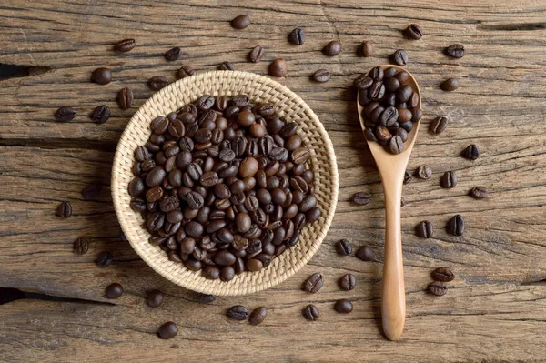 木製の背景に枝編み細工品バスケットでコーヒー豆 — ストック写真