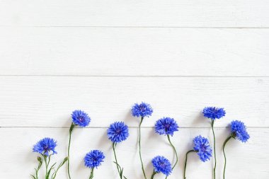 Eski beyaz ahşap arka planda mavi çiçek manzarası. Çiçek hattı, düz uzan.