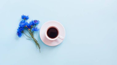 Bir fincan kahve, sıcak çikolata ve açık mavi arkaplanda bir buket mavi çiçek. Yaz yatağı. Yaşam biçimi, kopyalama alanı, modelleme.