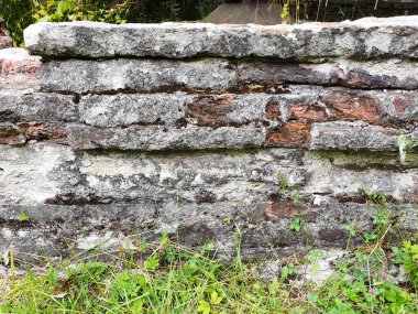 Eski duvar ve çimenler harap olmuş. Eski ev, harabeler, arka plan. Yan görünüm.