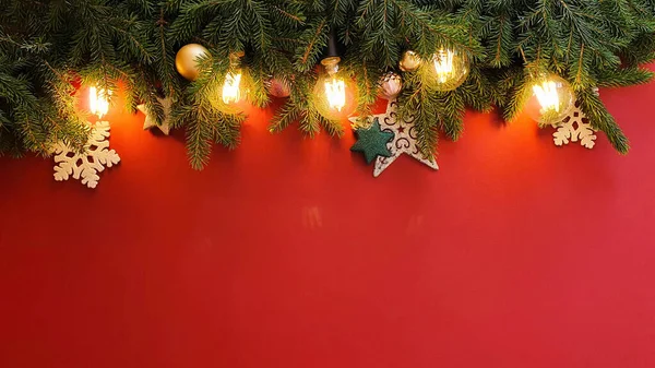 Christmas border / frame. Fir tree, stars, balls and magic lights on red background . Atmospheric frame, place for text or your product. Christmas flatlay style, mockup