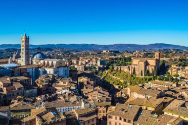 Güneşli bir sabahta Siena şehri manzarası. Soldaki Siena Katedrali, soldaki ise Basilica Cateriniana veya Basilica San Domenico..