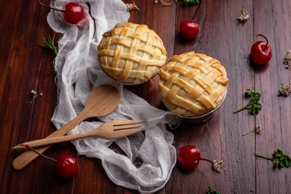 木製のテーブルの上に赤いチェリーとミニココナッツパイ 自家製ベーカリーのコンセプト — ストック写真