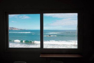 Plaj ve deniz manzaralı pencere.
