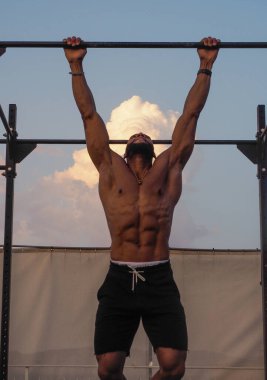 Kaslı adam trisepsi uzatıyor.