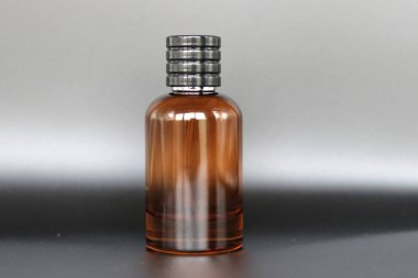 Siyah arka planda etiket ya da çıkartma olmayan kırmızı renkli cam parfüm şişesi.