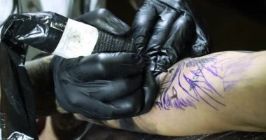 Müşterinin koluna dövme sanatçısı çizimi