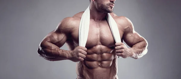 Strong Athletic Man Pokazuje Ciała Mięśni Brzucha Szarym Tle — Zdjęcie stockowe