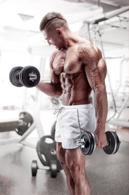 Halter salonunda ile çalışmaları yapan kaslı vücut geliştirmeci adam