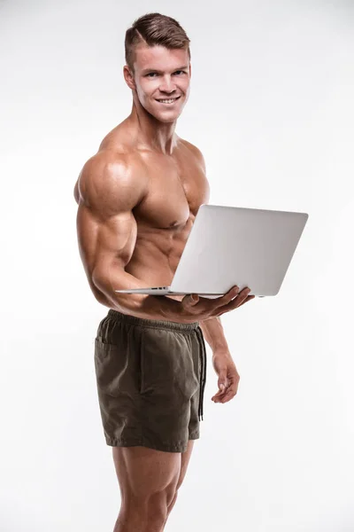 Muscular fisiculturista com laptop — Fotografia de Stock