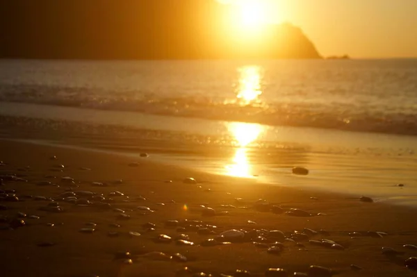 日の出は海とぬれた石の滑らかな表面に反映されます — ストック写真