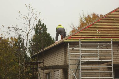 Çatıdaki inşaat işçisi.