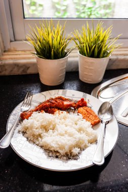 Beyaz pirinç, kızarmış tavuk ve hindistan cevizi, tempeh ve sambal ezmesi de dahil olmak üzere Endonezya usulü yemekler bir mutfakta çatal ve kaşıkla servis edilir. Endonezya geleneksel yemeği