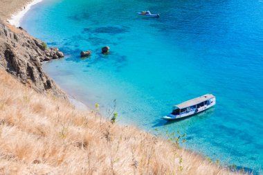 Padar Adası 'ndan manzara, Komodo Ulusal Parkı, Endonezya. Padar Adası kıyısında bir turist teknesi..