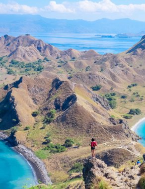 14 Haziran 2018 - Labuan Bajo, Komodo Ulusal Parkı, Endonezya: Kırmızı hırkalı Asyalı kız Padar Adası 'nın tepesinde manzaranın keyfini çıkarıyor