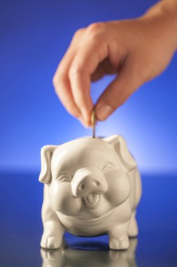 Piggy Bank and hand  on background,close up clipart