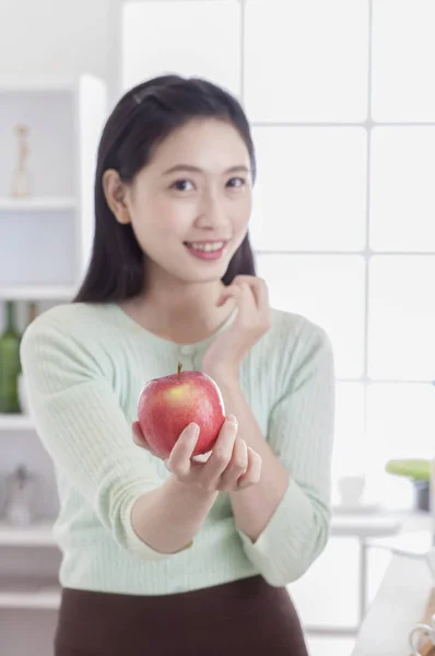 Νεαρά Ασιατικές Γυναίκα Στέκεται Στην Κουζίνα Κρατώντας Ένα Μήλο Και — Φωτογραφία Αρχείου