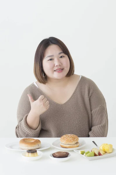 Junge Dicke Asiatische Frau Sitzt Neben Einigen Lebensmitteln Und Zeigt — Stockfoto