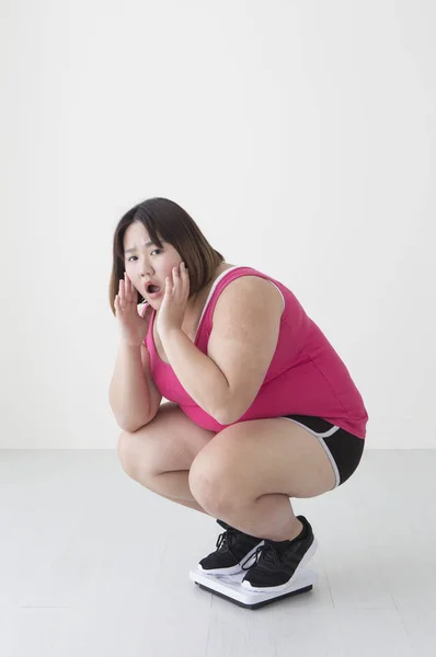 Young Fat Asian Woman Squatting Weight Scale Looking Shocked — Stock Photo, Image