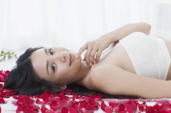 Mladá Asijská Žena Ležící Posteli Růžemi Dívá Kamery — Stock fotografie