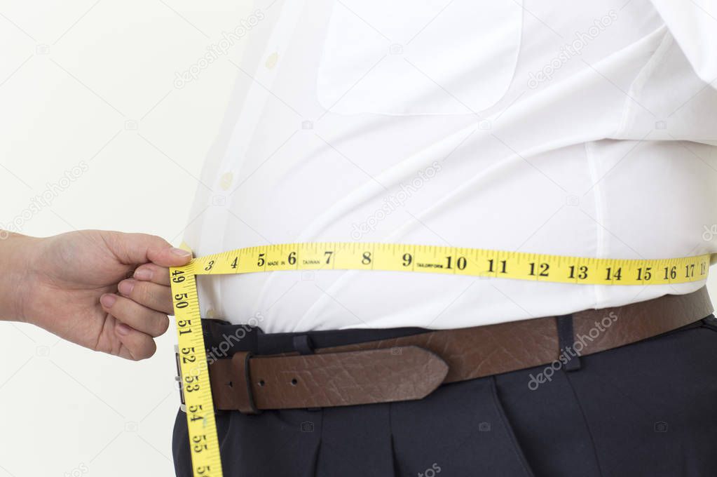Young fat Asian man measuring his waist with a tape,