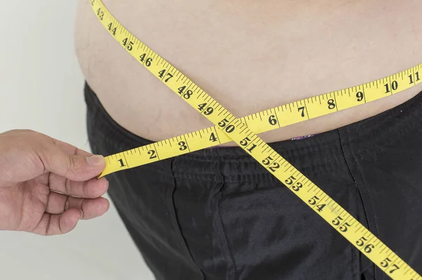 Young fat Asian man measuring his waist,