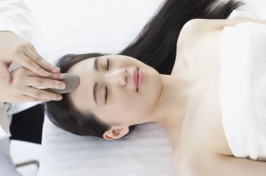 Yaptığı masajdan sonra yüzünde Genç Asyalı kadın