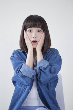 Yanağında ve kameraya şok arıyorsunuz bir kot ceket genç kadında eller