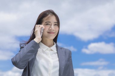 Evet ve kameraya gülümseyen bir takım elbise giymiş genç Asyalı kadın