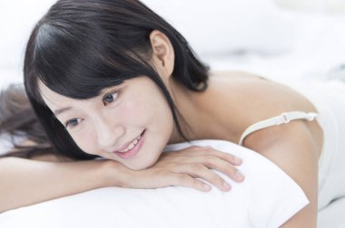 Yatakta yatıyordu ve uzağa arıyorsunuz gülümseyen genç kız