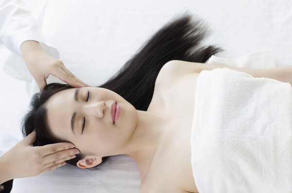 Молодая азиатка получает массаж от китайского врача
