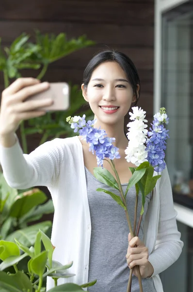 若い女性の花を押し Selfie を取って笑顔 — ストック写真