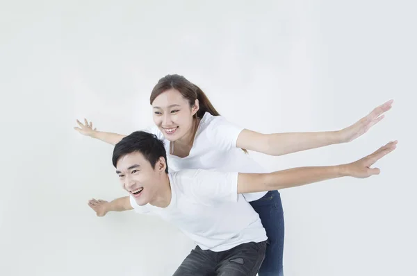 Young couple arms open and smiling looking away
