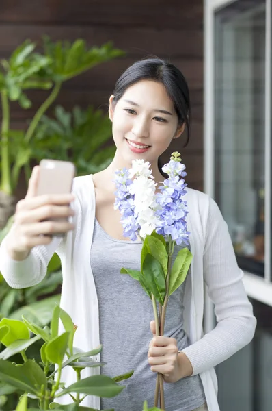 若い女性の花を押し Selfie を取って笑顔 — ストック写真