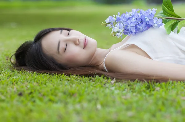 Молода Азіатка Білому Платті Лежить Траві Посміхається Квіткою — стокове фото