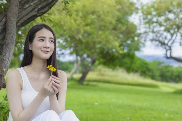 年轻的亚洲女人抱着一朵花 微笑着望着 — 图库照片